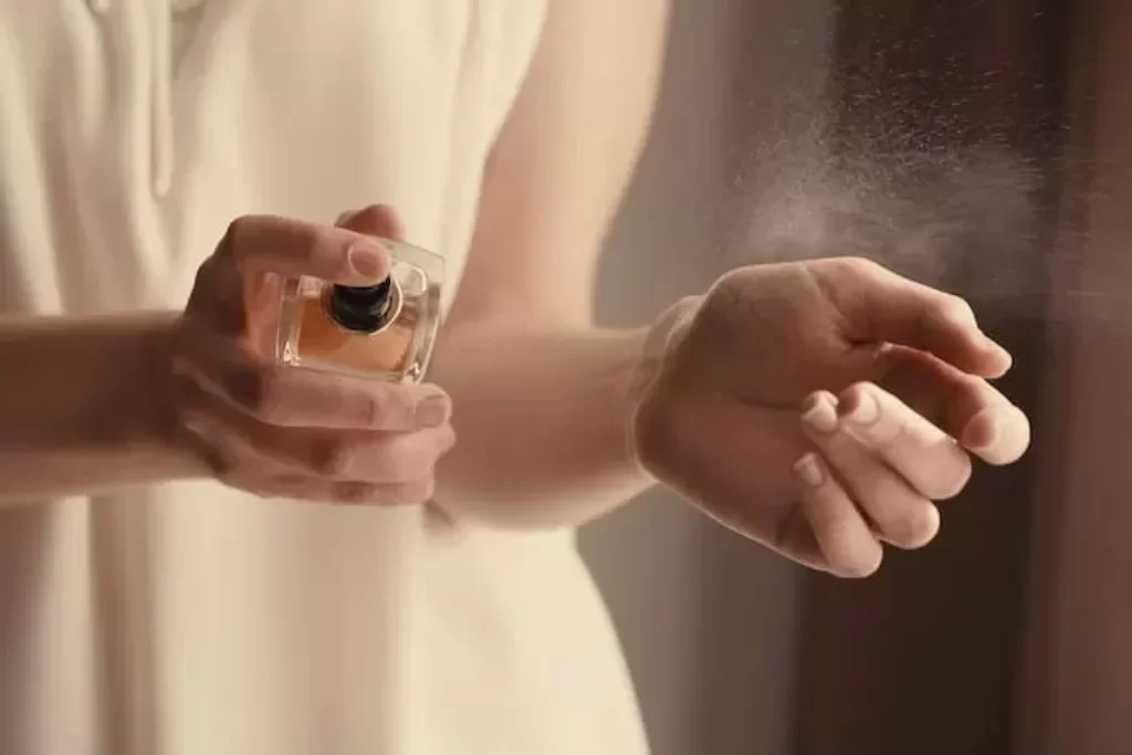 Mulher passando perfume no pulso