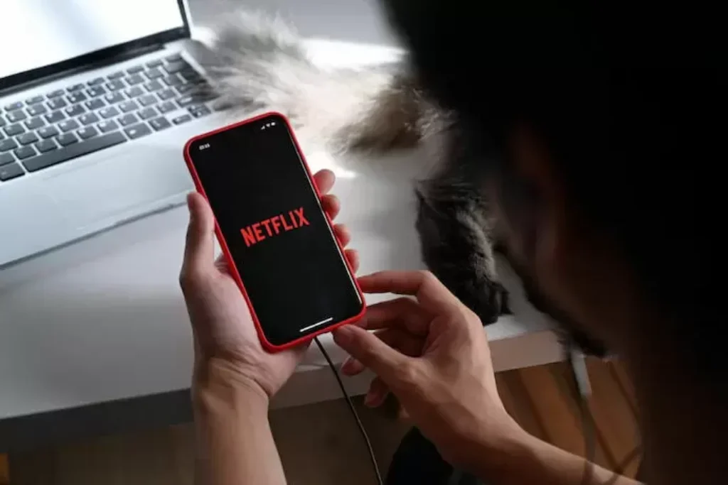 Alguém com celular assistindo netflix