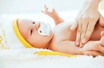 Uma mãe com a mão na barriga de um bebê.