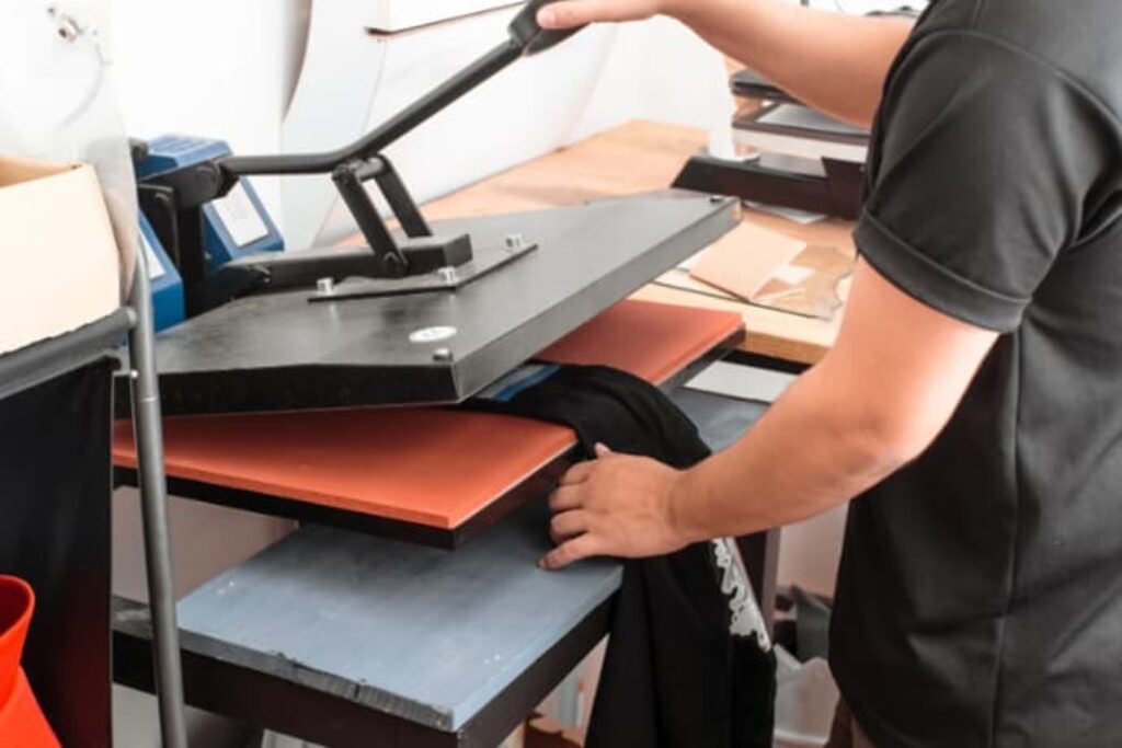 Alguém usando a máquina de estampar camisetas