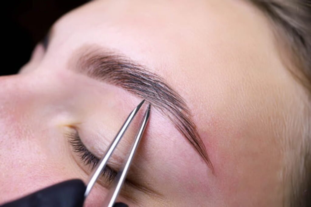 pinça para sobrancelha sendo usada em uma mulher