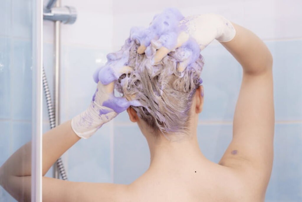 Mulher passando matizador no cabelo